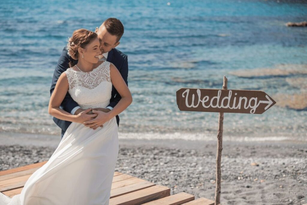 Bride and groom embracing with a Greek sunset in the background.