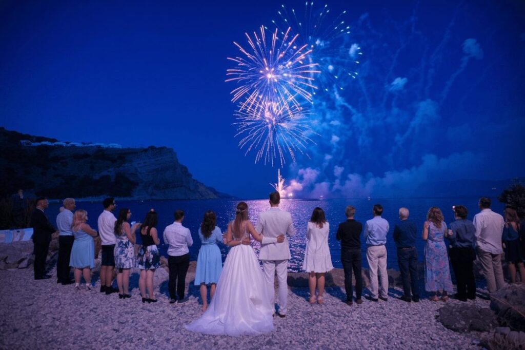 A wedding party watching fireworks at a wedding in Greece.