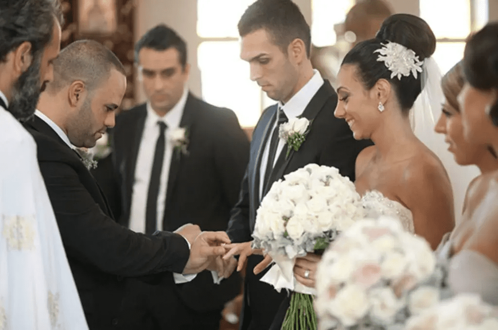 Bride and groom exchanging rings during a Greek Orthodox wedding ceremony, symbolizing their commitment