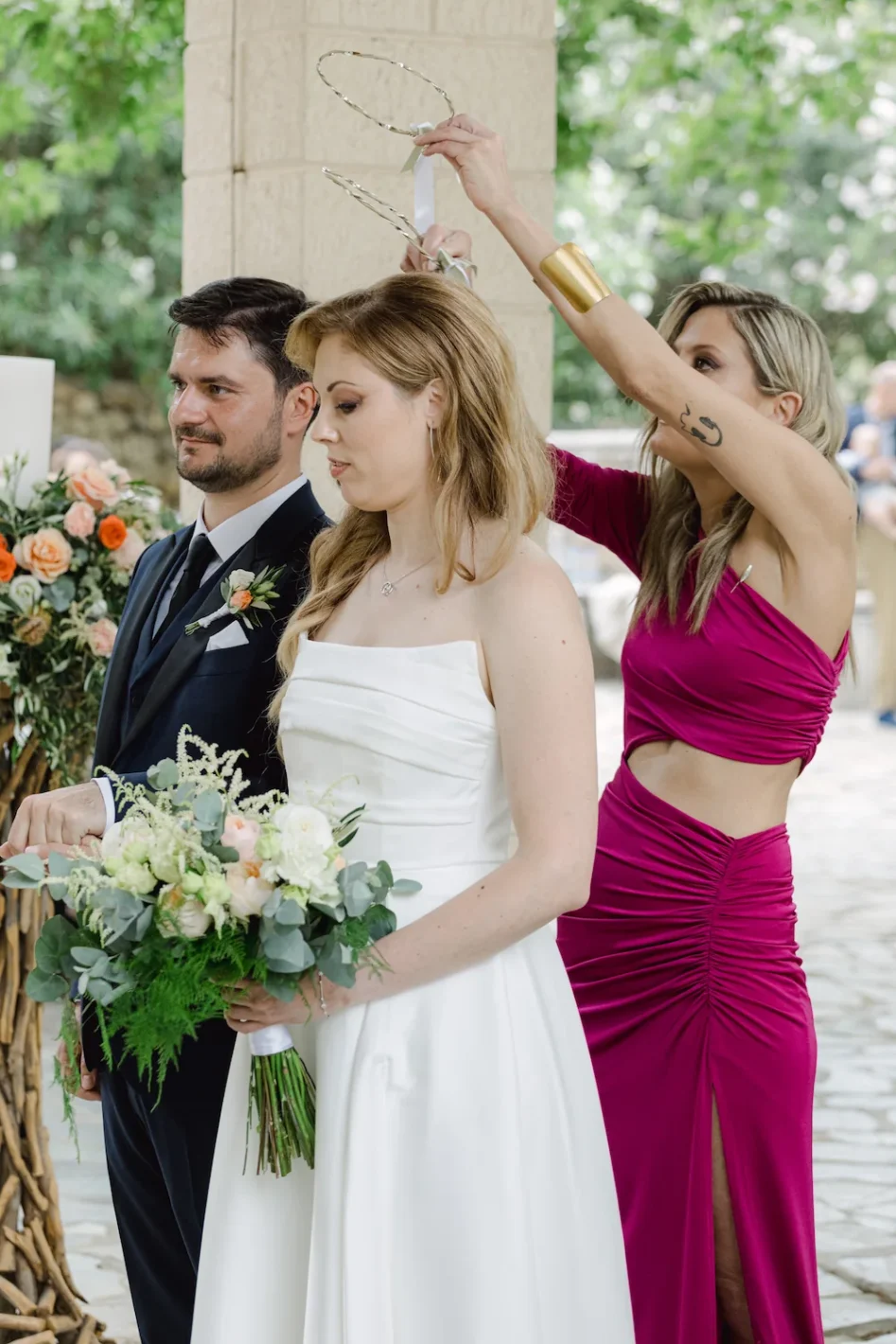 koumbara exchanging the stefana wedding crowns at a greek orthodox wedding
