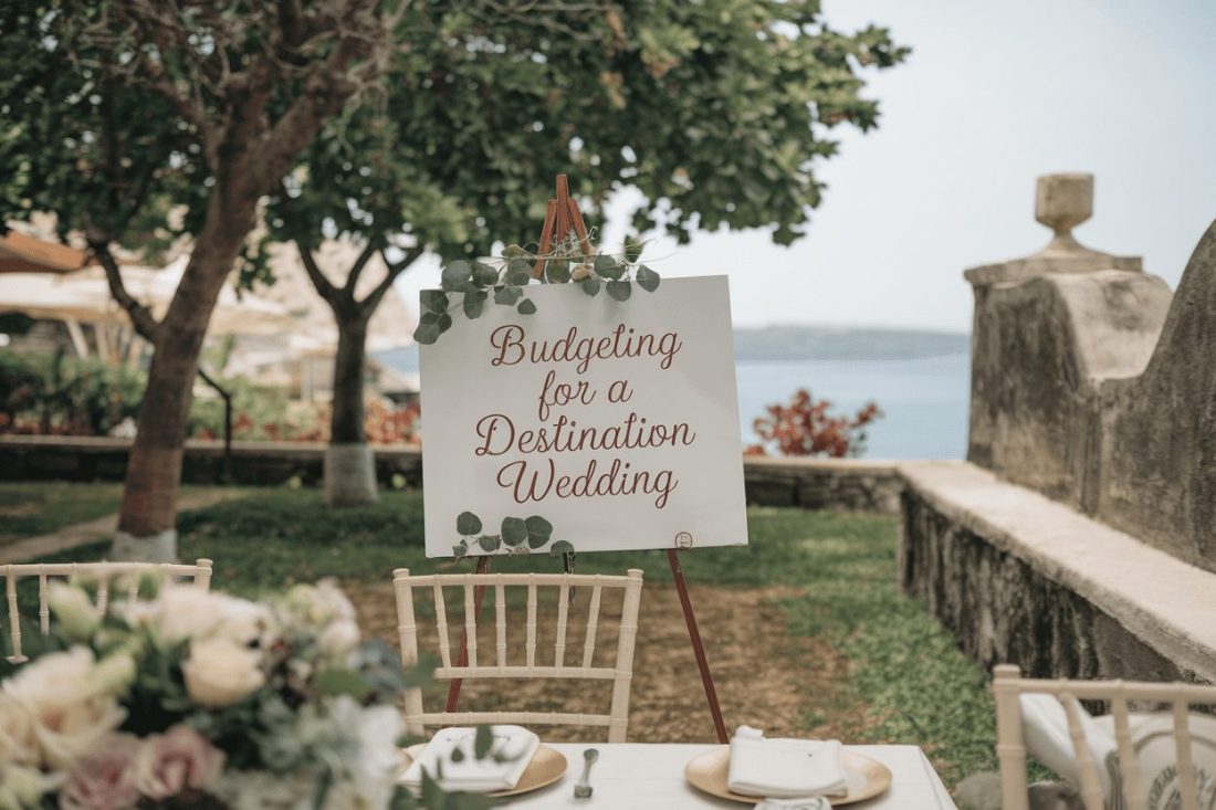 budgeting for a destination wedding in Greece with a table setting and easel sign
