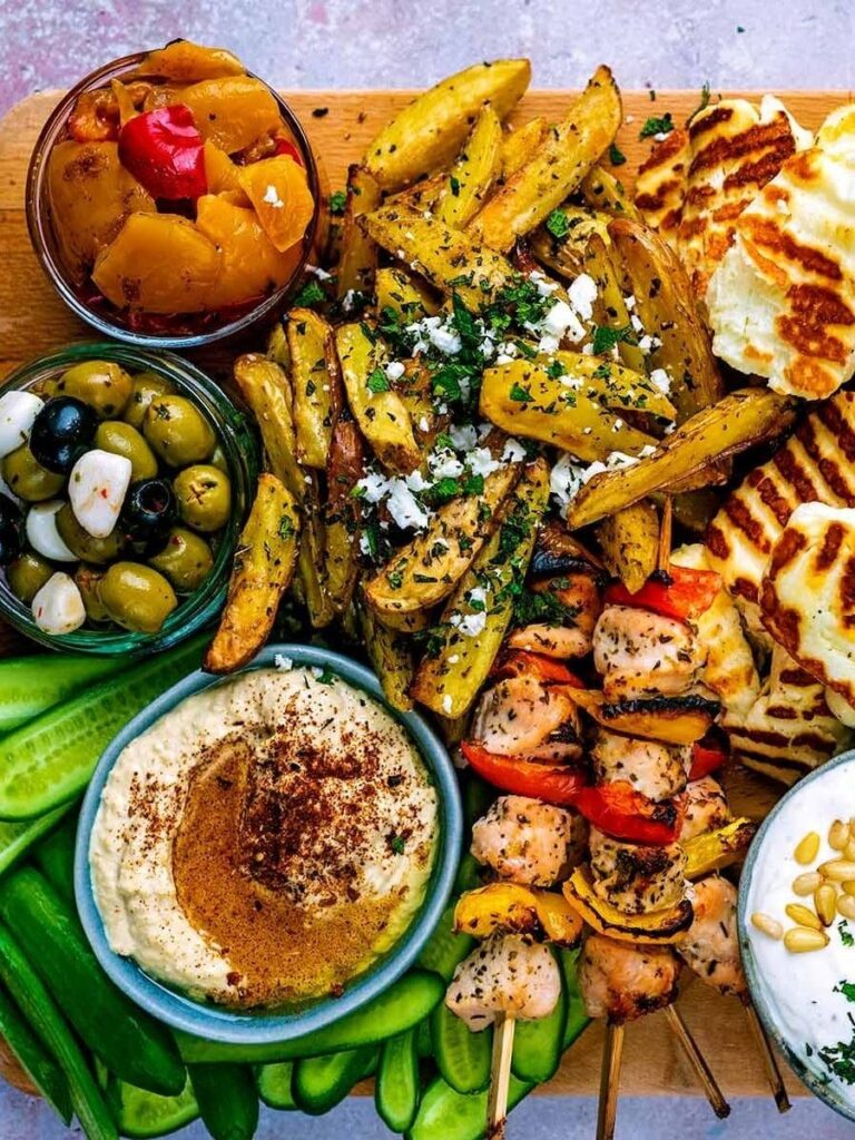 A Greek Mezze food platter with a mix of fresh and grilled food