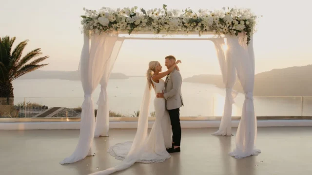a wedding couple embracing in front of the aegean horizon at a santorini wedding venue