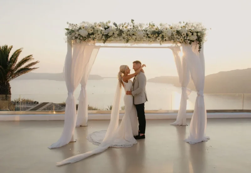 a wedding couple embracing in front of the aegean horizon at a santorini wedding venue