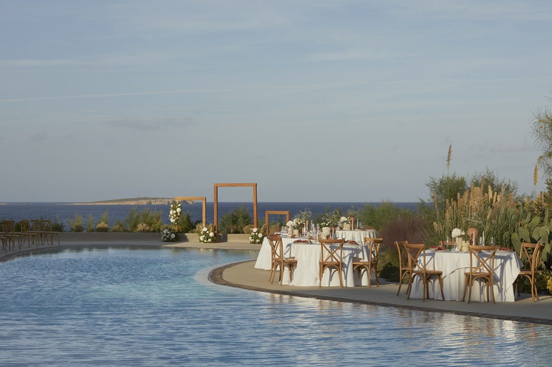 Poolside wedding tables set beside the infinity pool at Parocks Luxury Hotel and Spa, Ambelas, Paros, with the Aegean behind