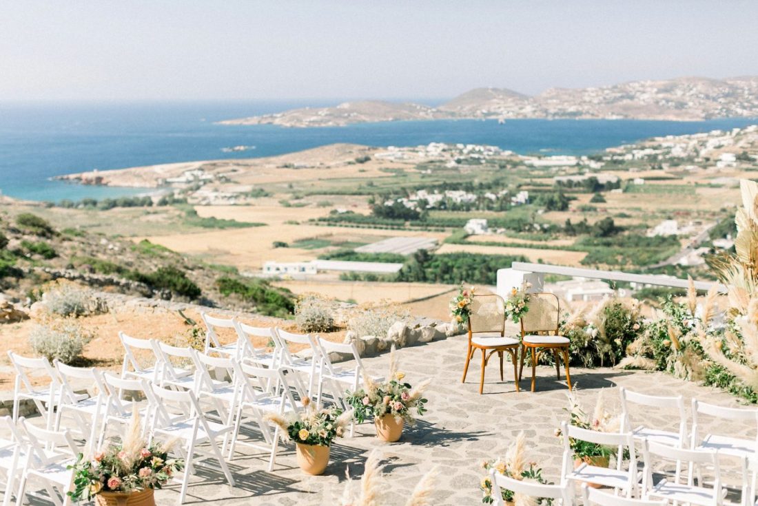 Outdoor ceremony set up with white chairs on the cliffside terrace at Villa Mira Paros, overlooking the Bay of Parikia