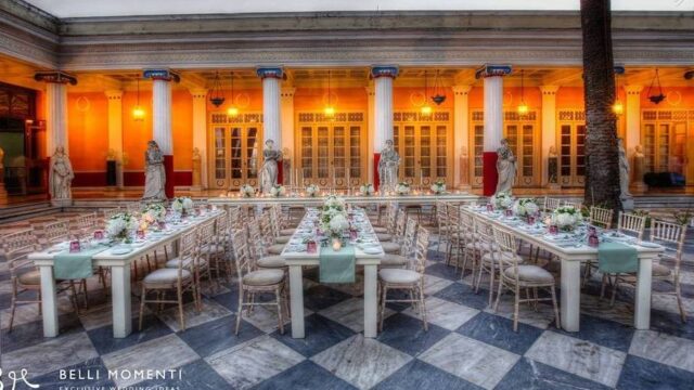 a beautiful outdoor hall setup for a greek wedding with many tables and decorations