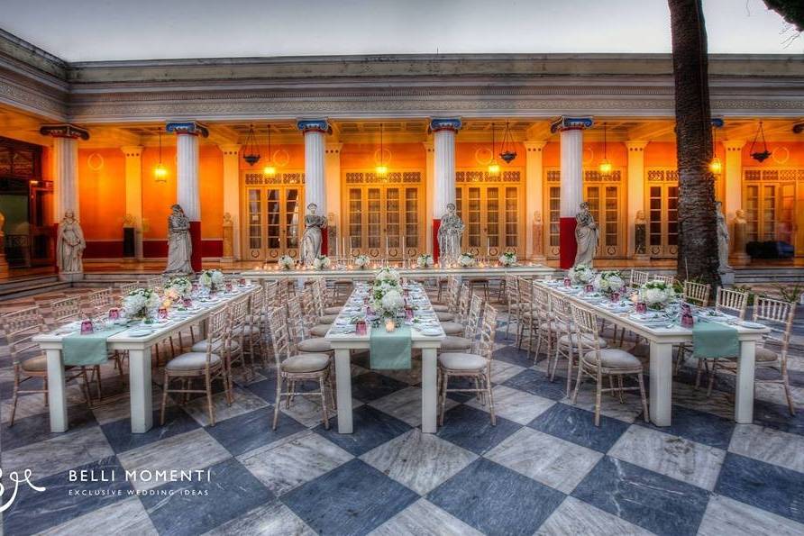 a beautiful outdoor hall setup for a greek wedding with many tables and decorations