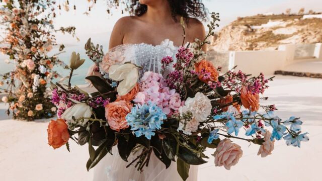 a bride holding a colorful bouquet at a santorini wedding