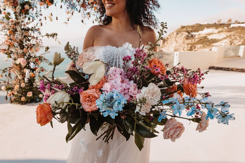 a bride holding a colorful bouquet at a santorini wedding