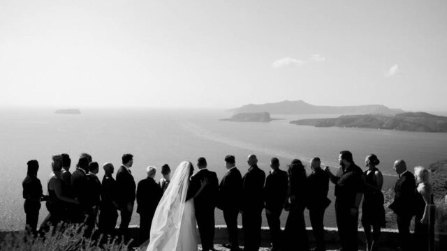 a wedding party overlooking the santorini caldera