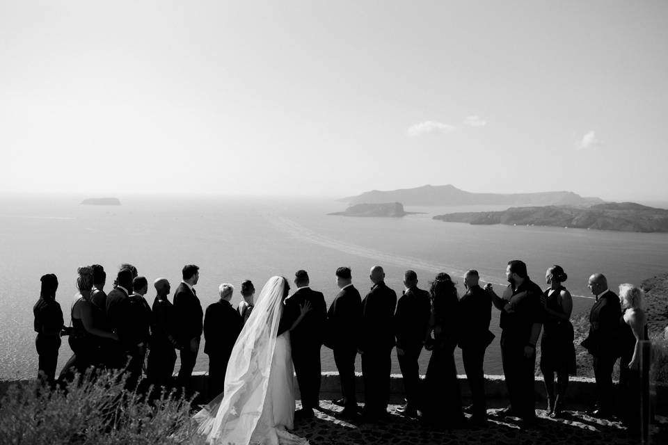 a wedding party overlooking the santorini caldera