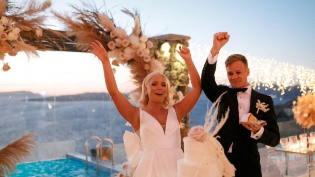 a couple about to cut the wedding cake in santorini