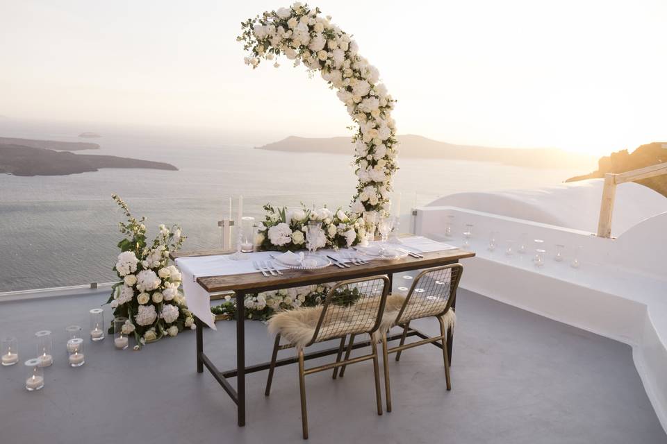 santorini wedding table with a flower arch