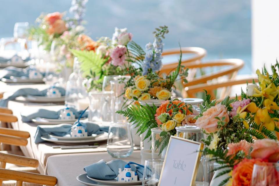 beautifully decorated wedding table in greece with the sea as a backdrop
