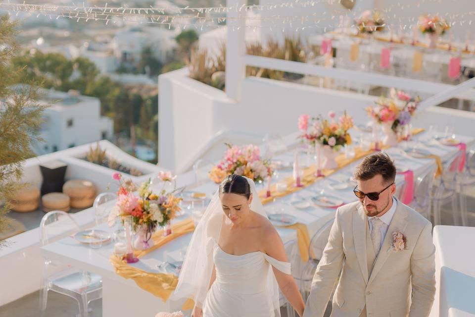 A newlywed couple holding hands at their wedding in greece