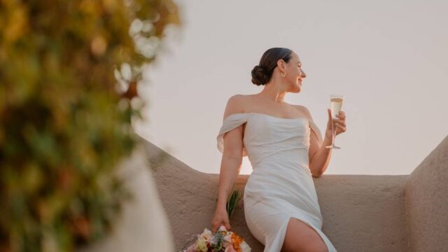 bride sipping champagne at a greek wedding