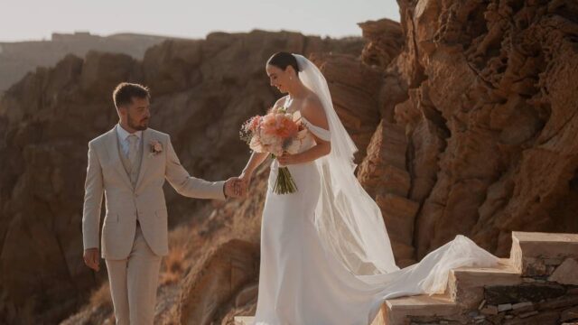brind and groom with a beautiful greek cliff backdrop