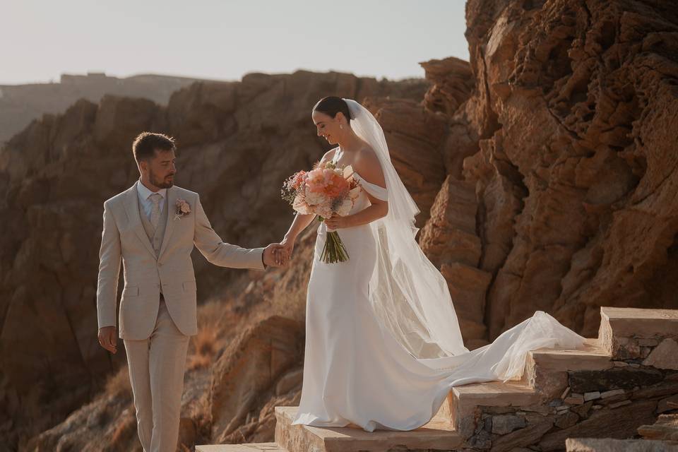 brind and groom with a beautiful greek cliff backdrop