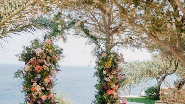 flower wedding arch overlooking the aegean sea in santorini