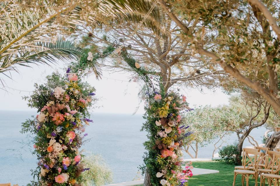 flower wedding arch overlooking the aegean sea in santorini