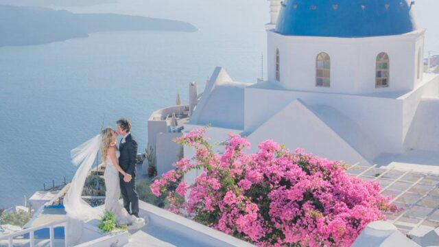 a couple kissing at a destination wedding in santorini