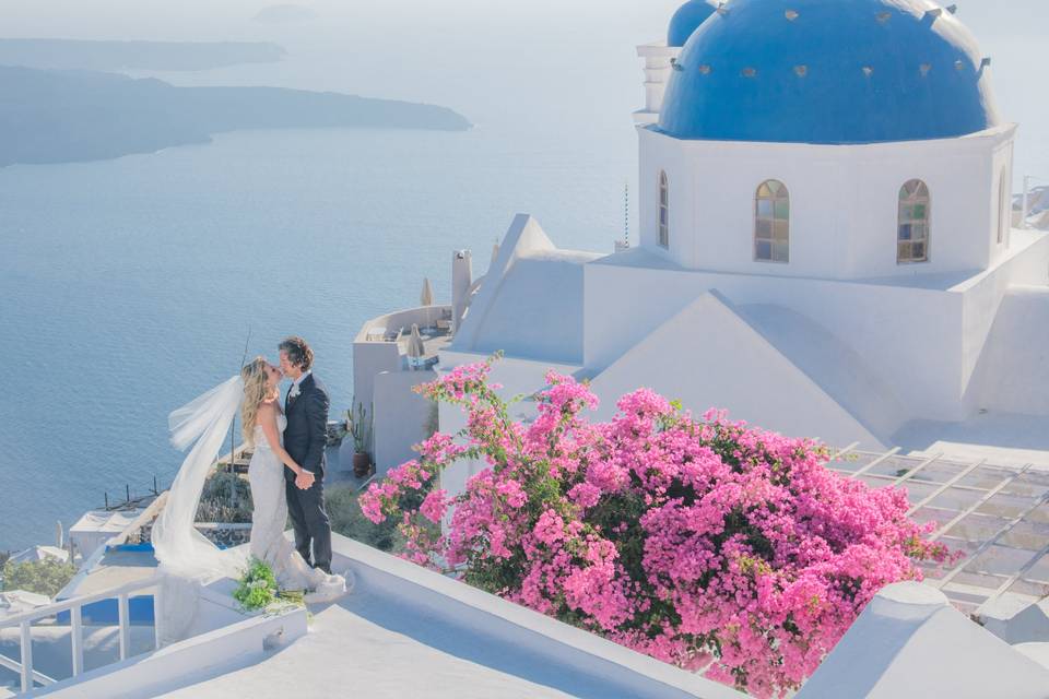 a couple kissing at a destination wedding in santorini