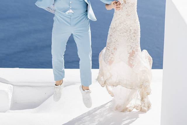 a couple jumping at a santorini destination wedding