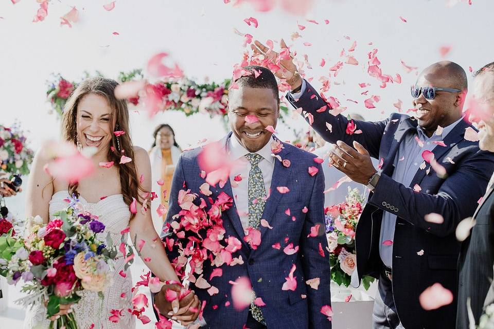 wedding couple showered in flowers at a greek wedding