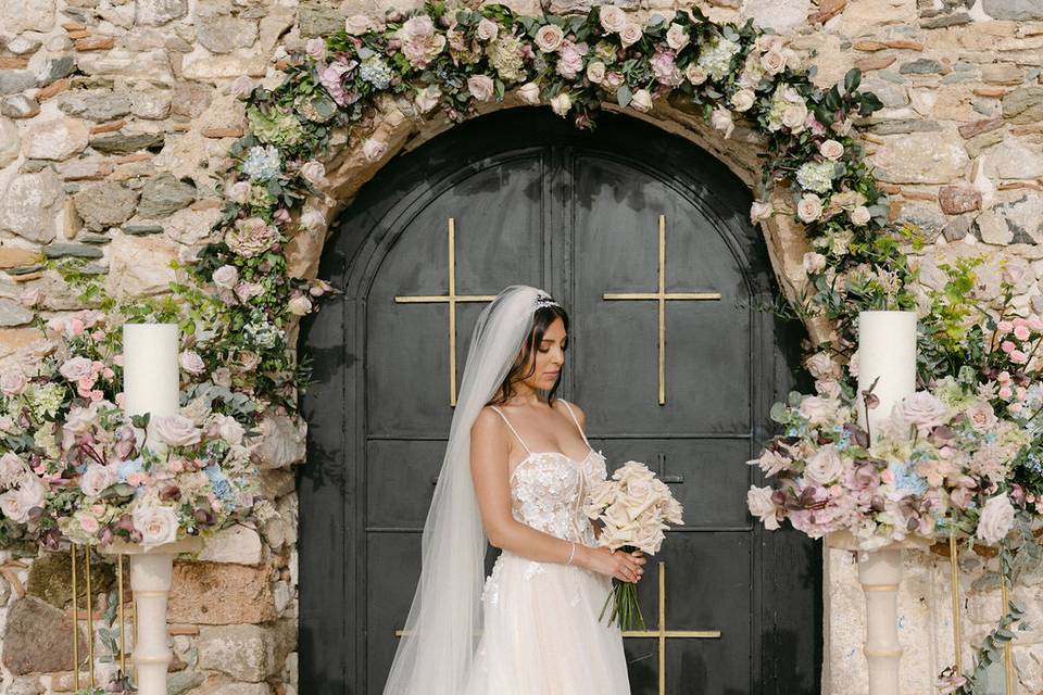 a beautiful bride surrounded by flowers at her greek wedding
