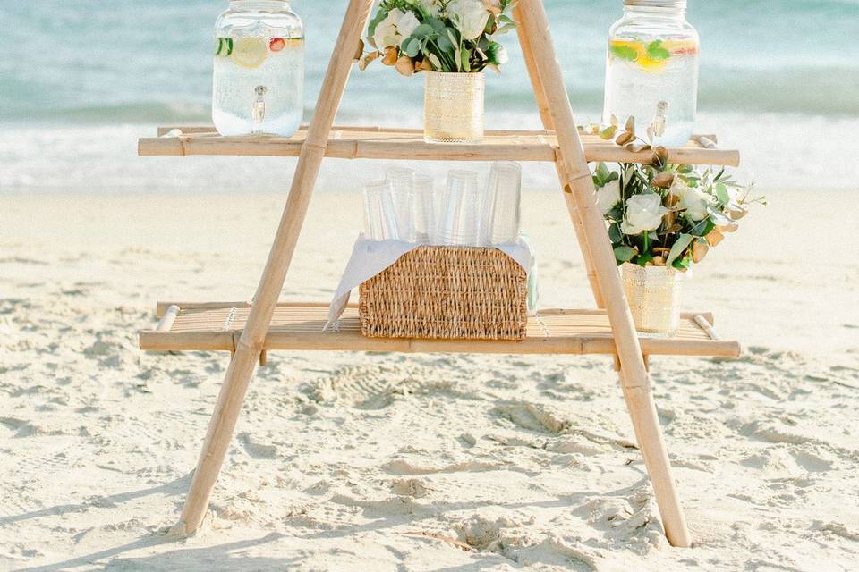 a water and flower station at a greek beach wedding