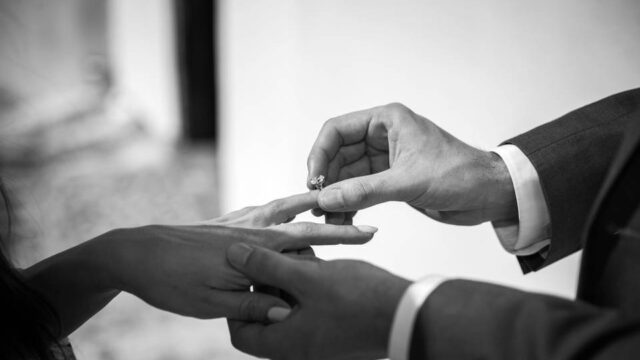 a man putting a ring on a woman's finger in greece
