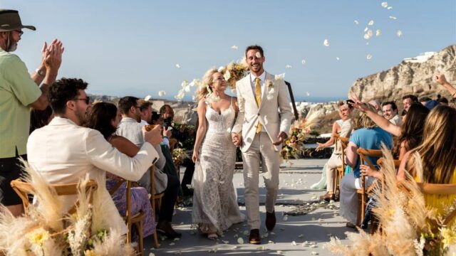 a newlywed couple walking down the aisle in greece