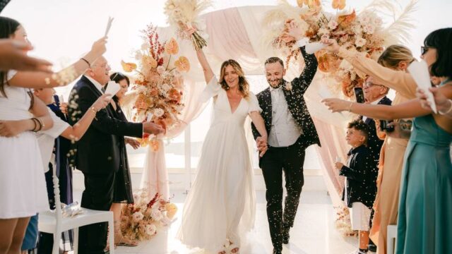 newlywed couple walking down the aisle at their santorini wedding