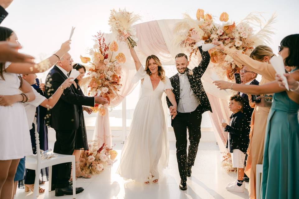 newlywed couple walking down the aisle at their santorini wedding