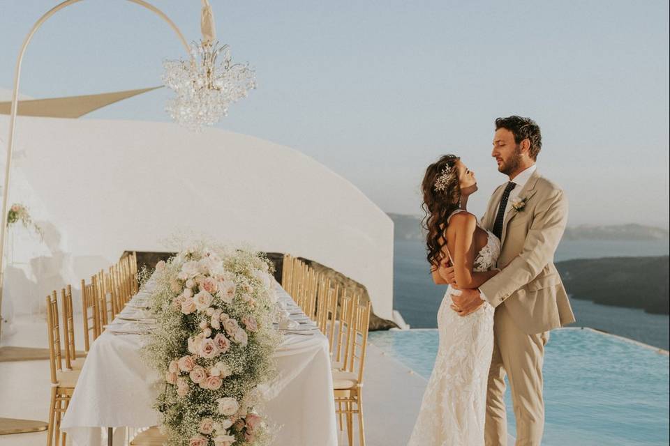 a wedding couple looking into each others eyes at their greek wedding
