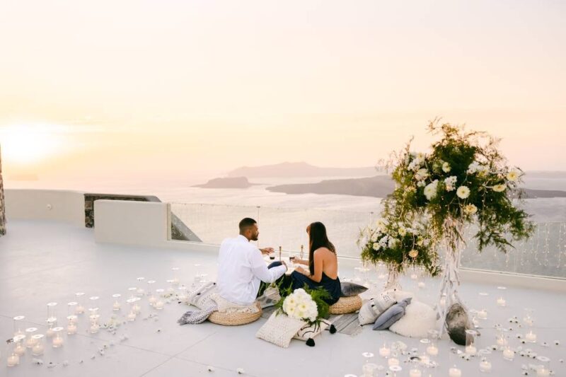 a wedding couple lounging in front of the santorini caldera