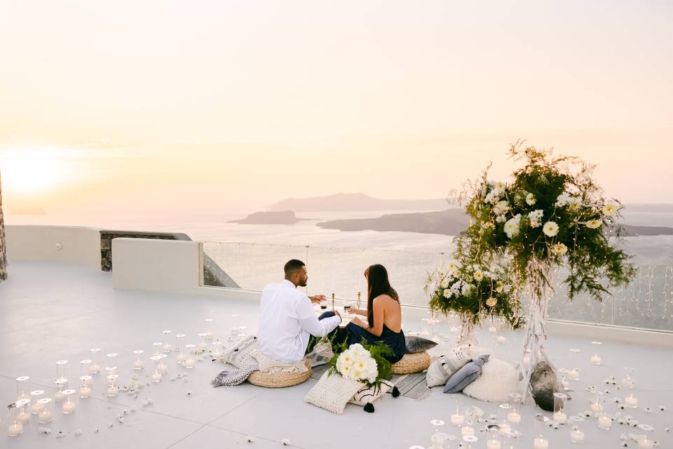 a wedding couple lounging in front of the santorini caldera