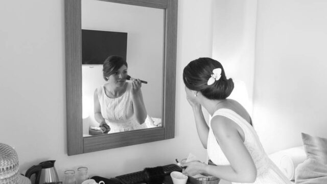 a greek bride putting on makeup