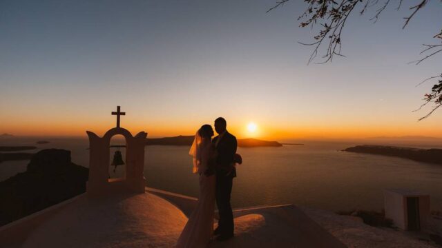 a couple a their wedding in greece watching the sunset