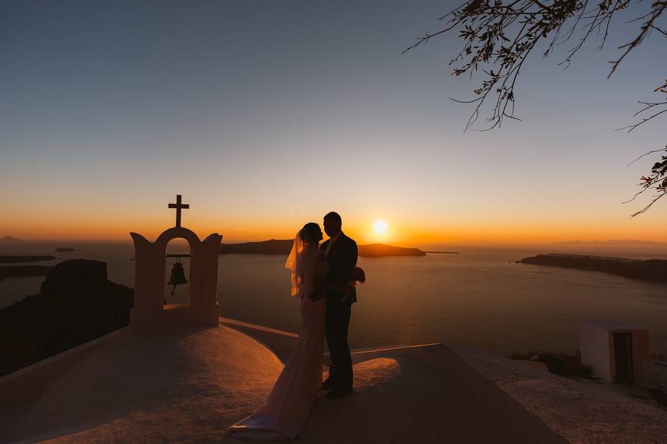 a couple a their wedding in greece watching the sunset