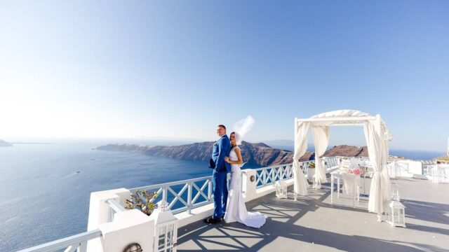 bride and groom looking out onto the santorini caldera