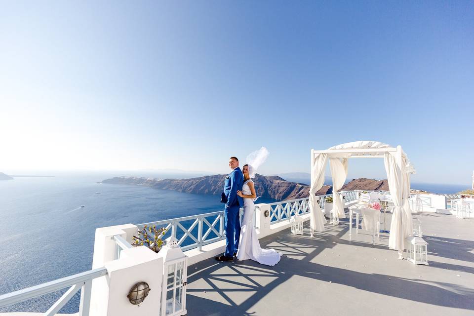 bride and groom looking out onto the santorini caldera
