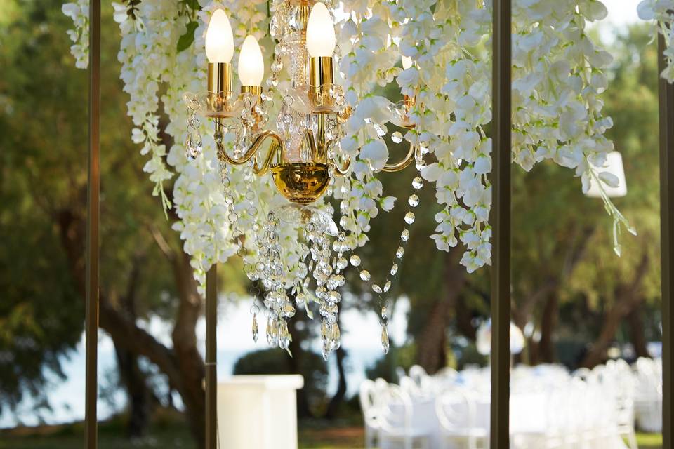 a chandelier with flowers at a greek wedding