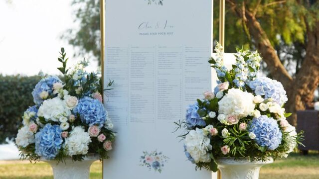 a seating chart surrounded by flowers for a greek wedding