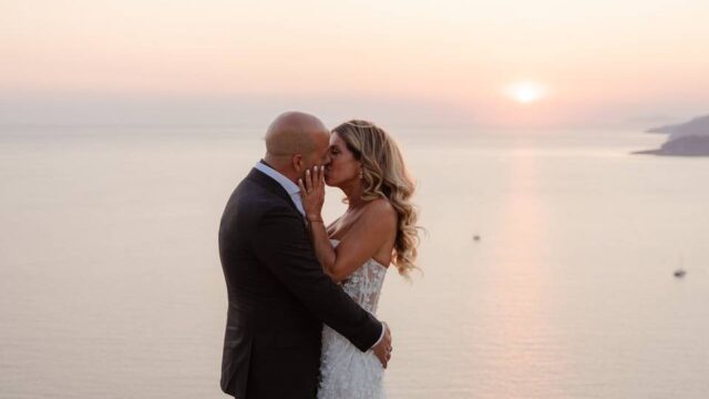 newlywed couple kissing in front of the aegean sea in greece