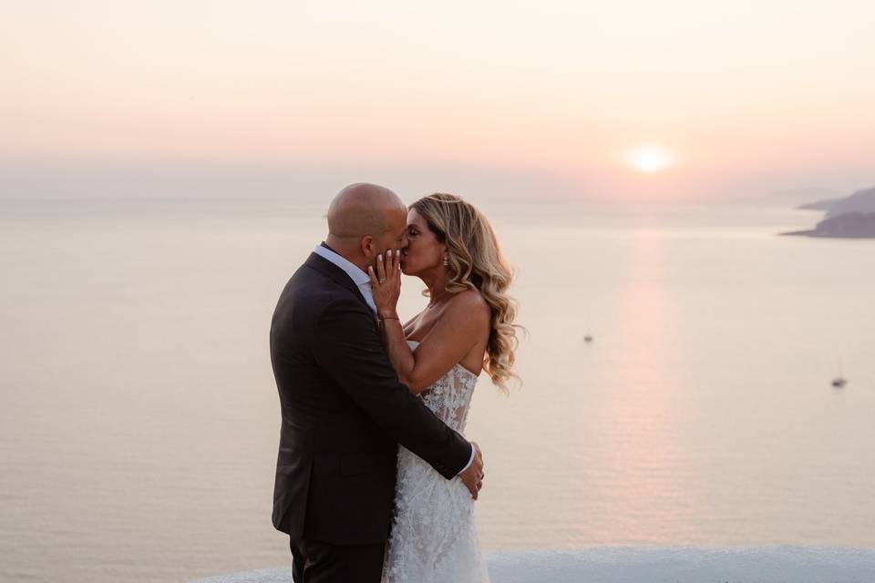 newlywed couple kissing in front of the aegean sea in greece
