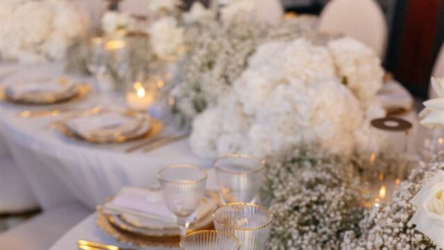 a beautifully decorated white wedding table with white flowers at a wedding in greece