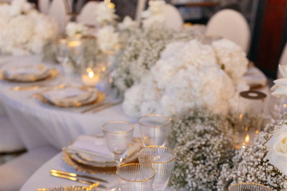 a beautifully decorated white wedding table with white flowers at a wedding in greece