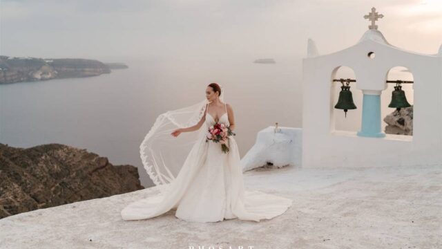 bride next to a chapel bell in santorini